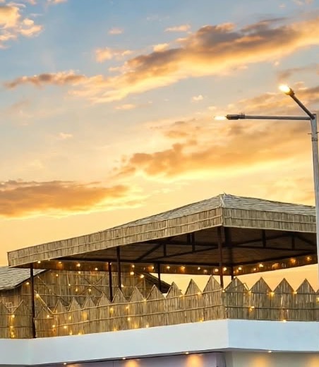 Rooftop restaurant in Pachpadra: Guru Kripa's bamboo canopy and string lights at sunset